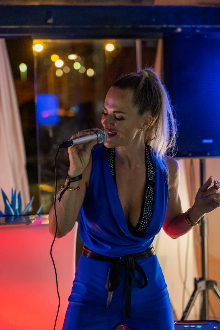 Danydeee singt live auf der Bühne im blauen Jumpsuit