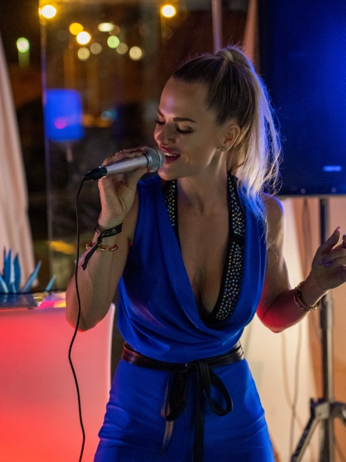 Danydeee singing live on stage in a blue dress