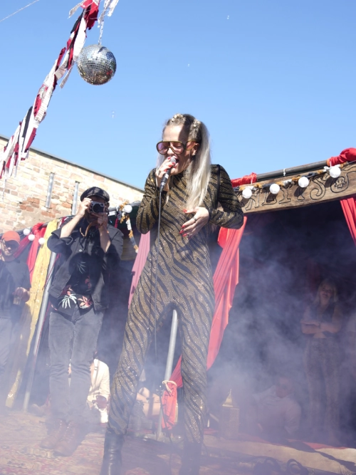 Silver-costumed stage performance with fog and stage lights